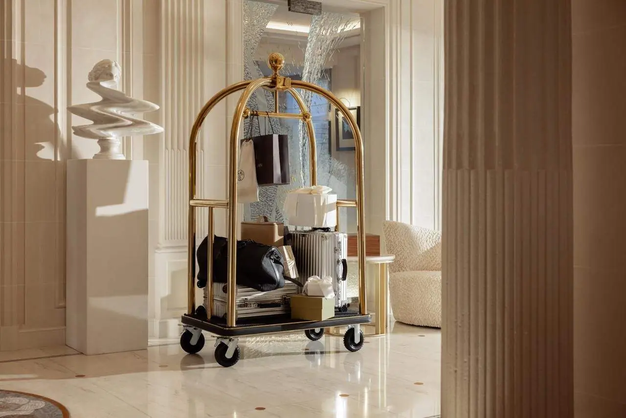 The entrance hall, gilded luggage trolley and fluted columns — Maison Bauchart