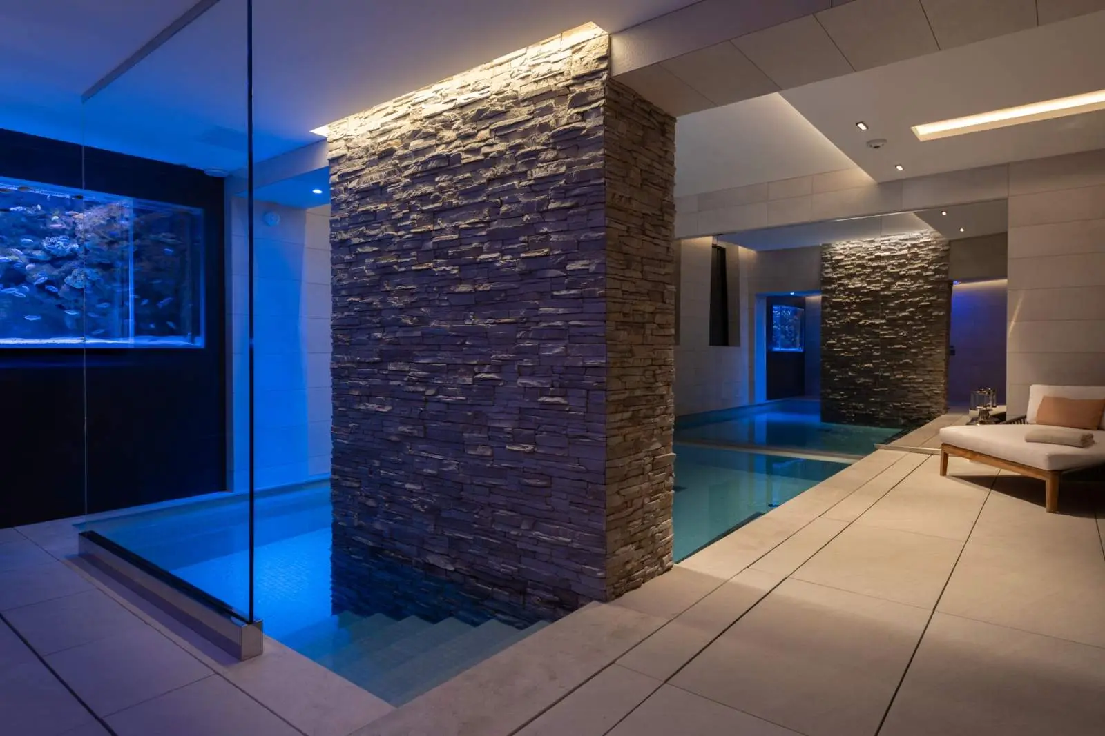 Spa pool lit in blue with an aquarium wall — Maison Bauchart