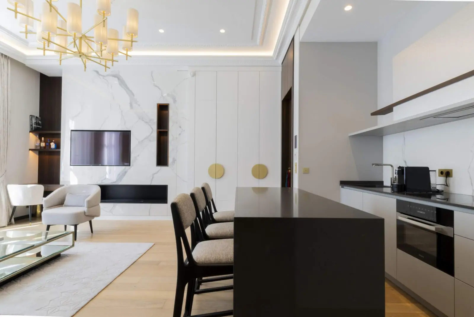 Bassano Suite, the living room and black-island kitchen — Maison Bauchart, Paris 8th
