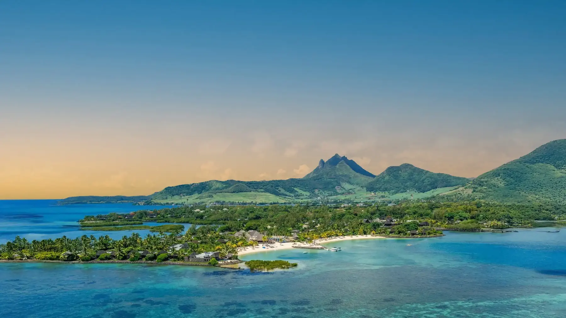 The Four Seasons peninsula at Anahita at dusk — beach, villas and the Bambou mountains