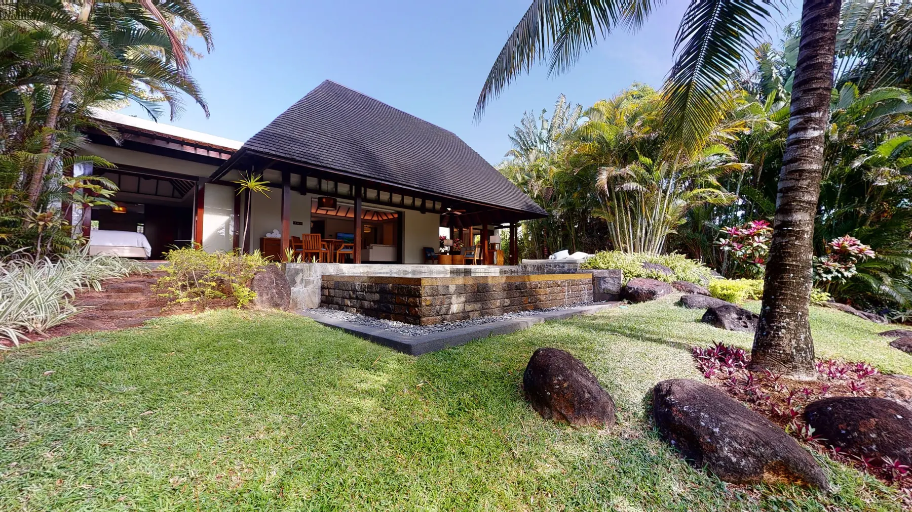 Four Seasons villa at Anahita — shingle roof, infinity pool in volcanic stone, tropical garden