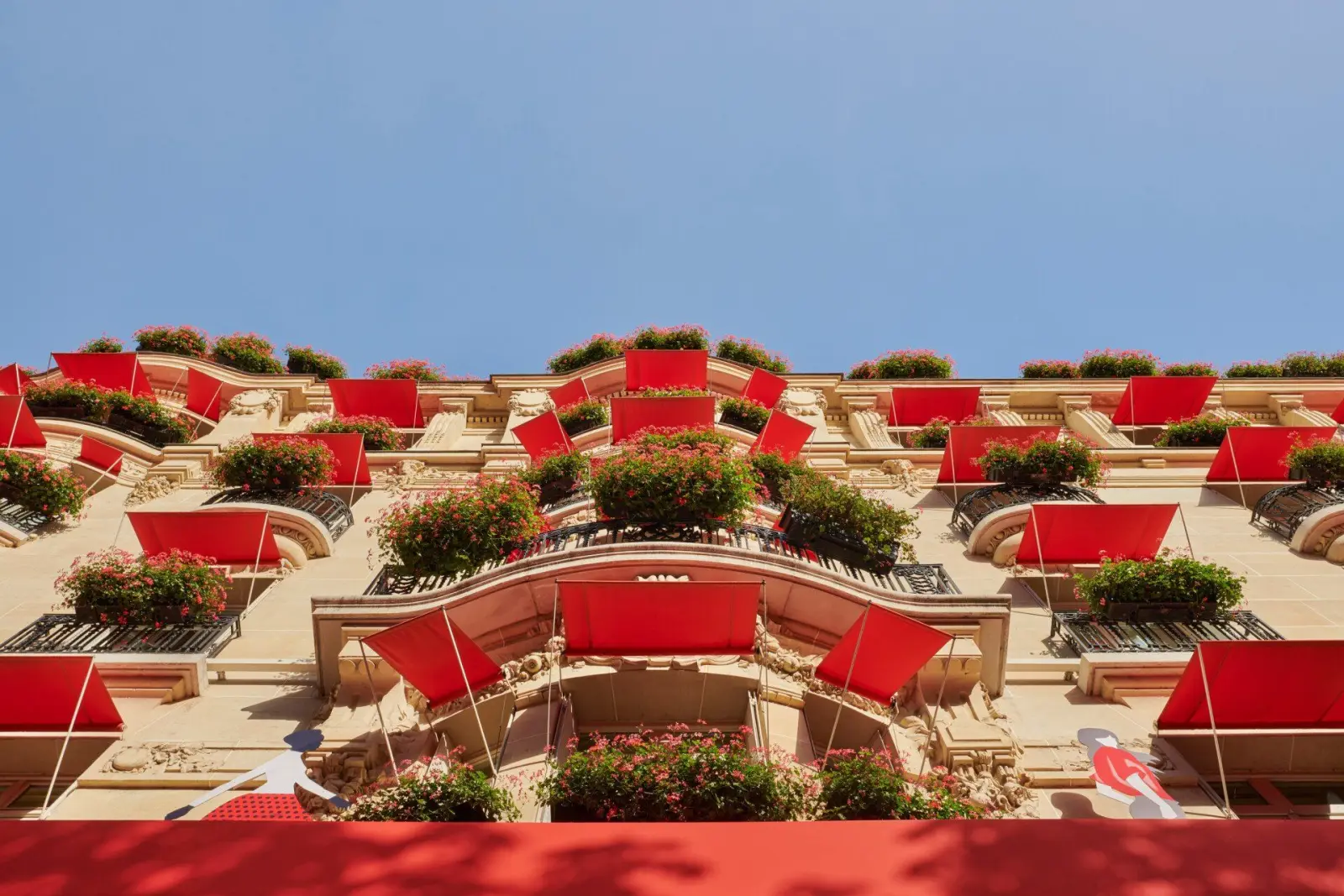 The façade with its red awnings and geraniums — Hôtel Plaza Athénée, avenue Montaigne
