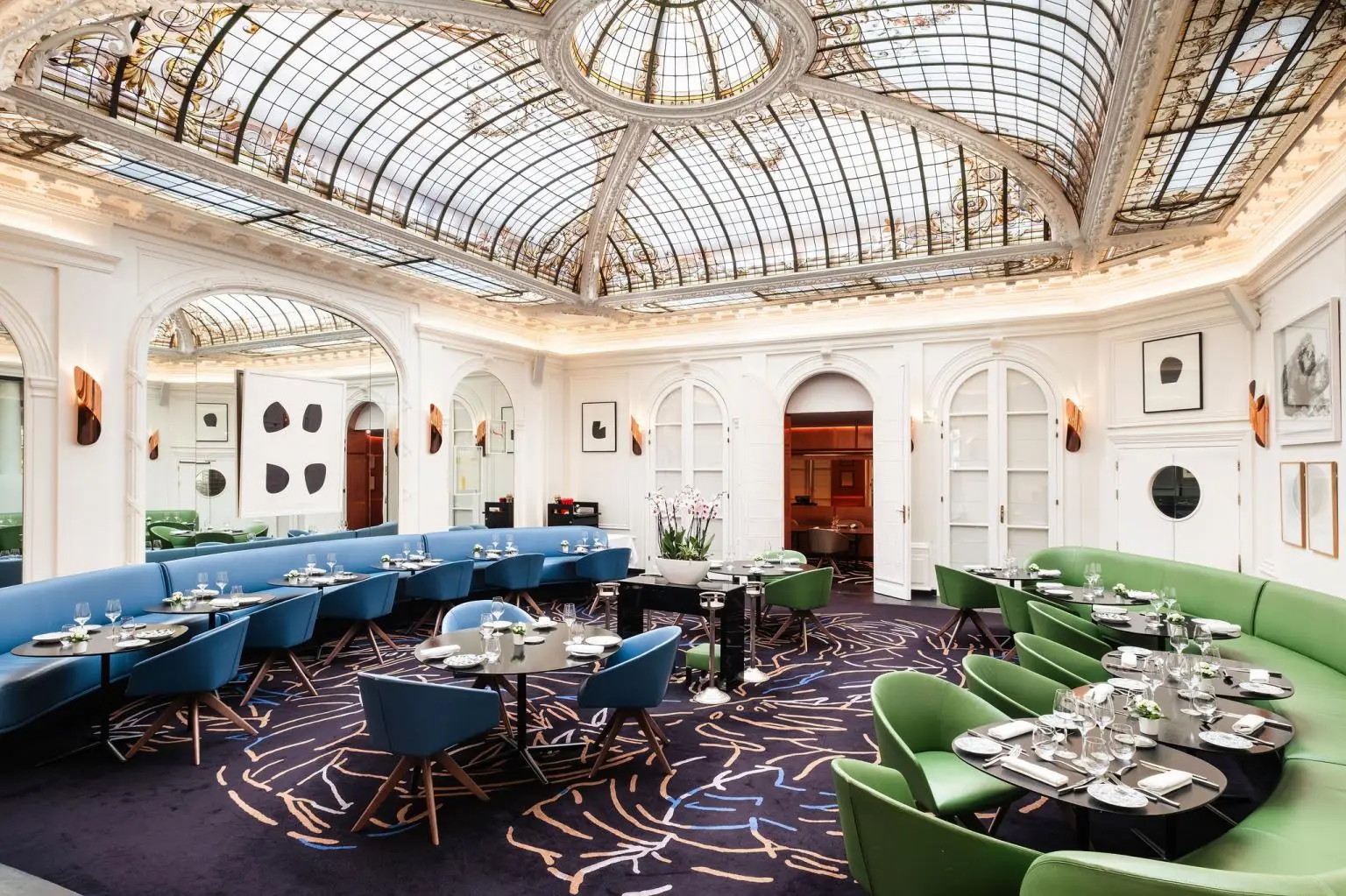 Le V restaurant beneath the glass roof framed by Gustave Eiffel — Hôtel Vernet